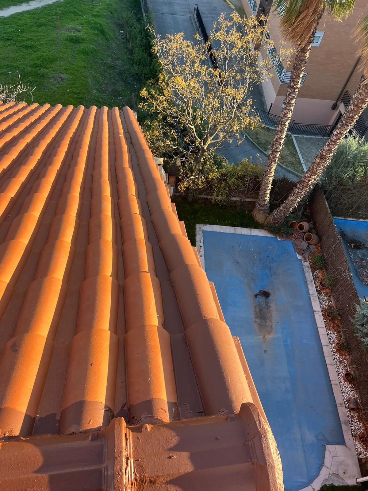 Una vista aérea de un tejado con una piscina al fondo.