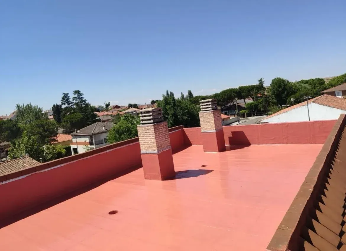 Un techo rojo con chimeneas encima