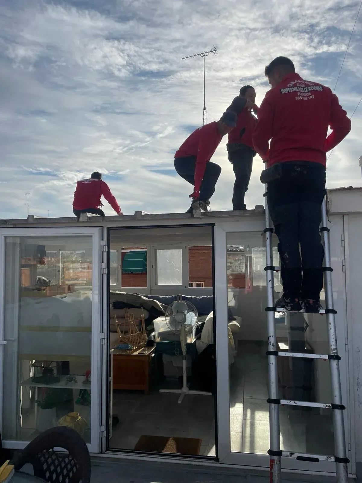 Un grupo de hombres está trabajando en el tejado de un edificio.