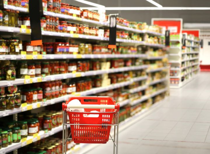 Un caddie est assis au milieu d'une allée dans un supermarché.