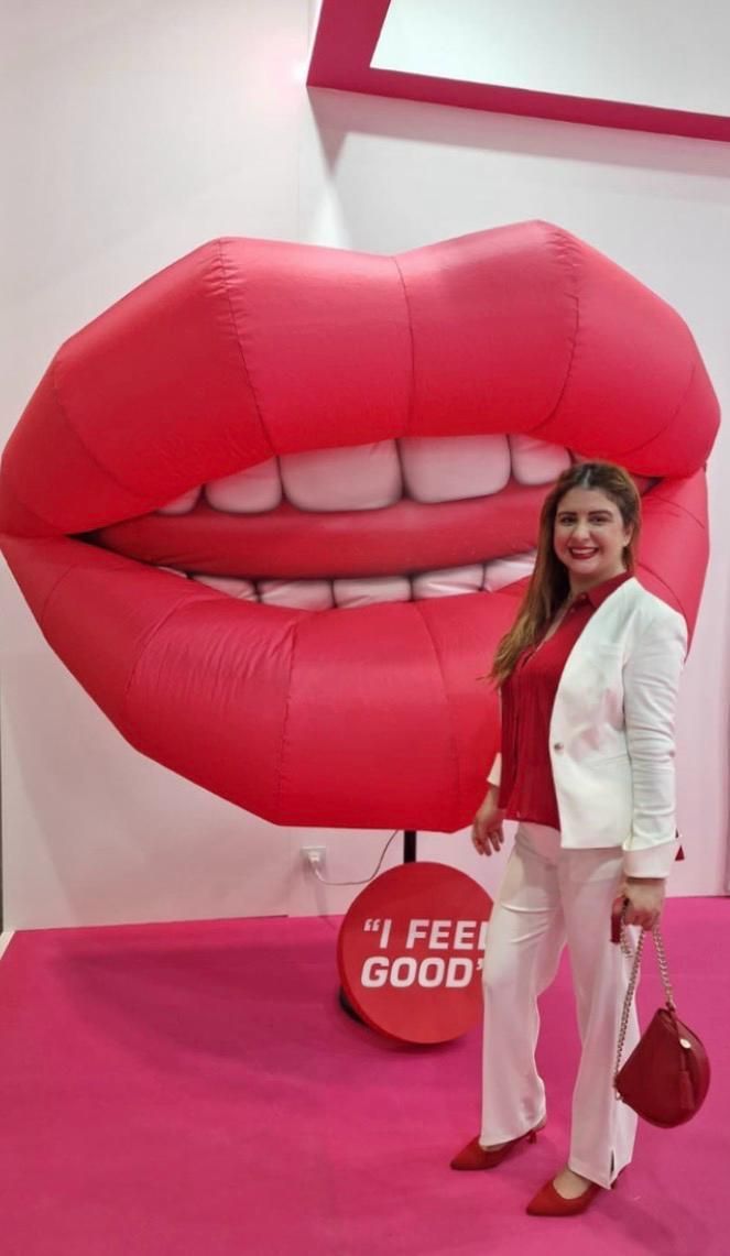 Persona en el sillón dental sonriendo, dentista examinando con herramientas. Guantes azules, babero verde, en el consultorio.