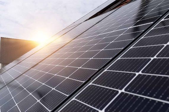 Solarpaneele, die zur Sonne hin ausgerichtet sind und Sonnenlicht reflektieren, auf dem Dach montiert.