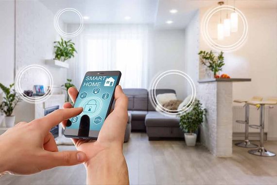 Eine Person steuert mit einem Smartphone Smart-Home-Funktionen. Im Hintergrund ist das Wohnzimmer zu sehen.