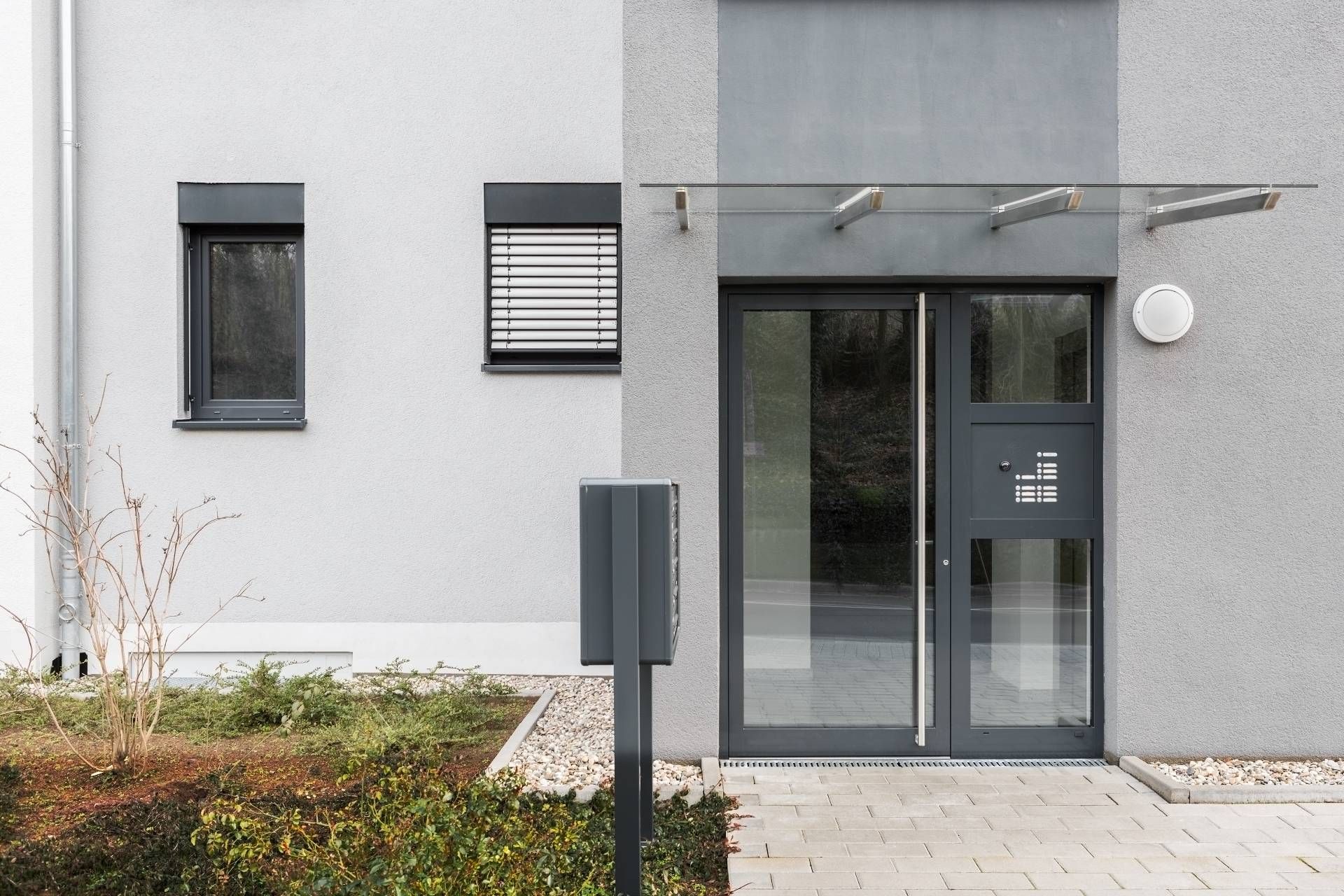 Die Eingangstür eines Gebäudes mit einem Glasdach darüber