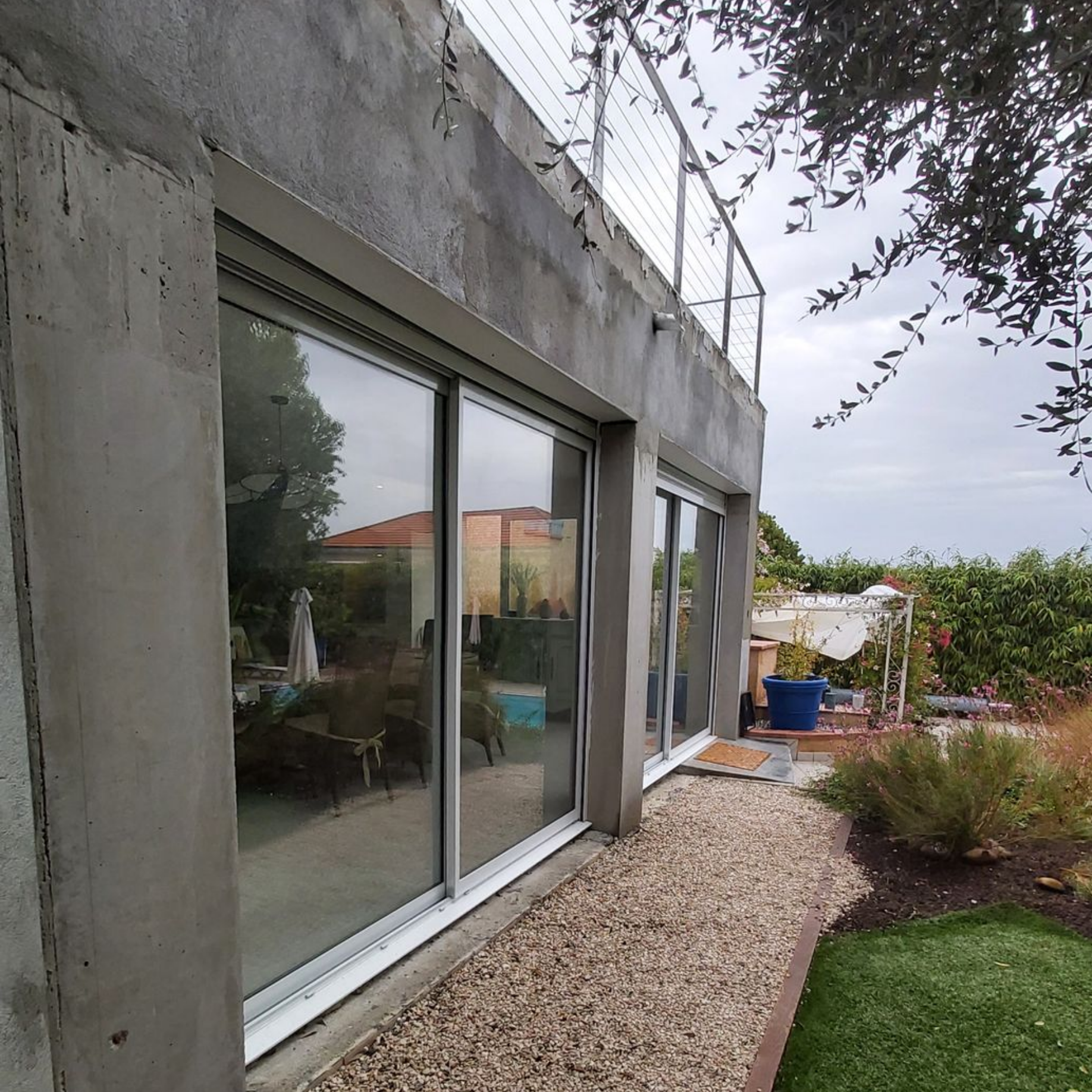 Extérieur d'un bâtiment moderne avec de grandes portes coulissantes en verre.