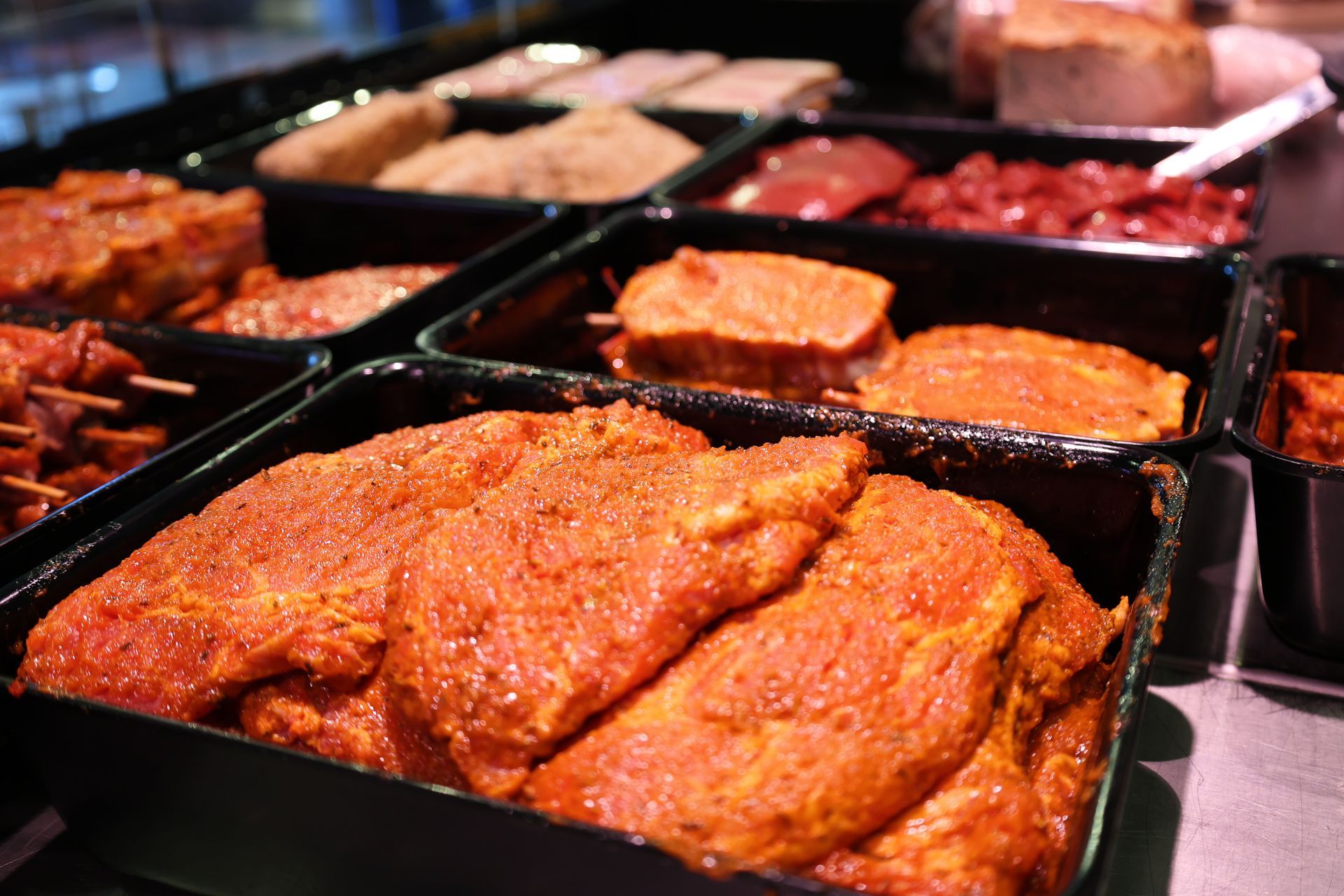 Fleischtheke mit verschiedenen Fleischsorten, darunter Hackfleisch und Würstchen.