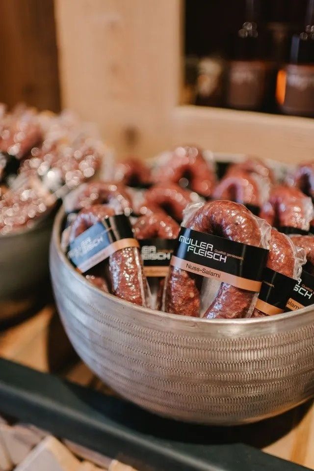 Schüssel mit abgepackten Würstchen mit schwarzen und braunen Etiketten.