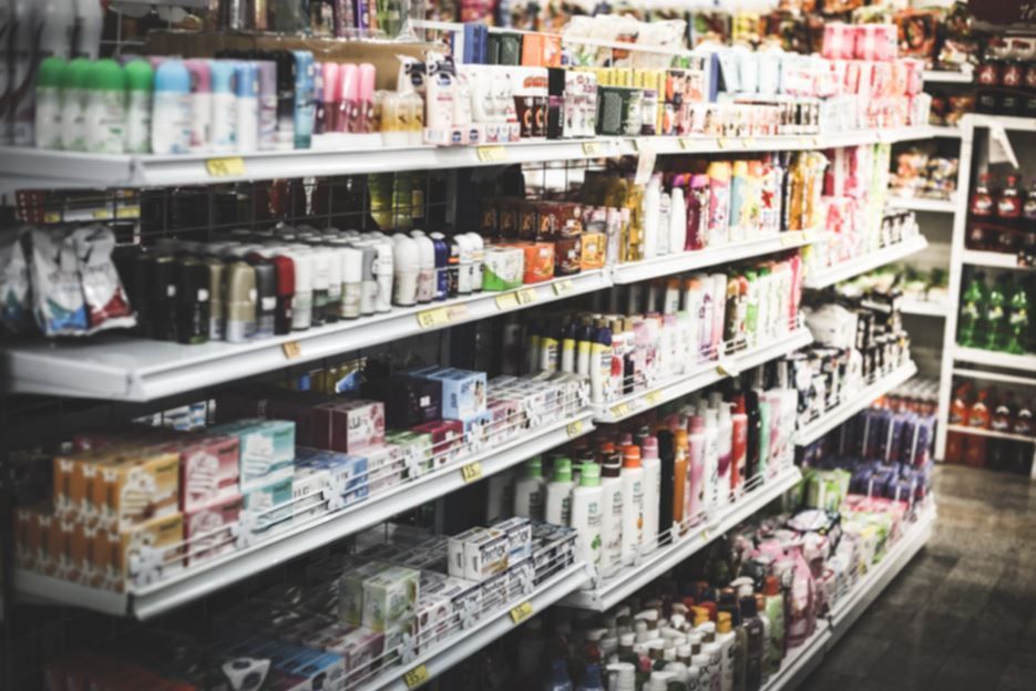 Estanterías repletas de diversos productos de consumo en una tienda.