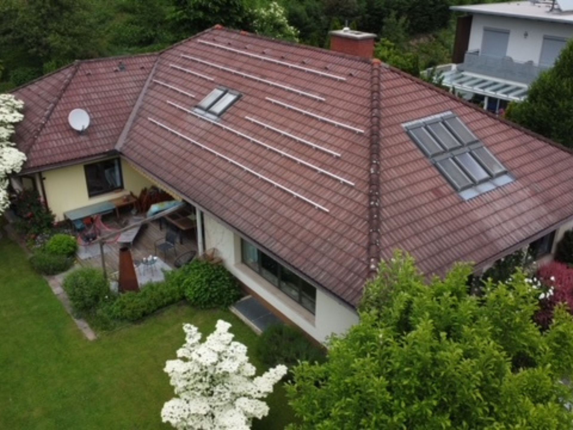 Eine Luftaufnahme eines Hauses mit Solarmodulen auf dem Dach