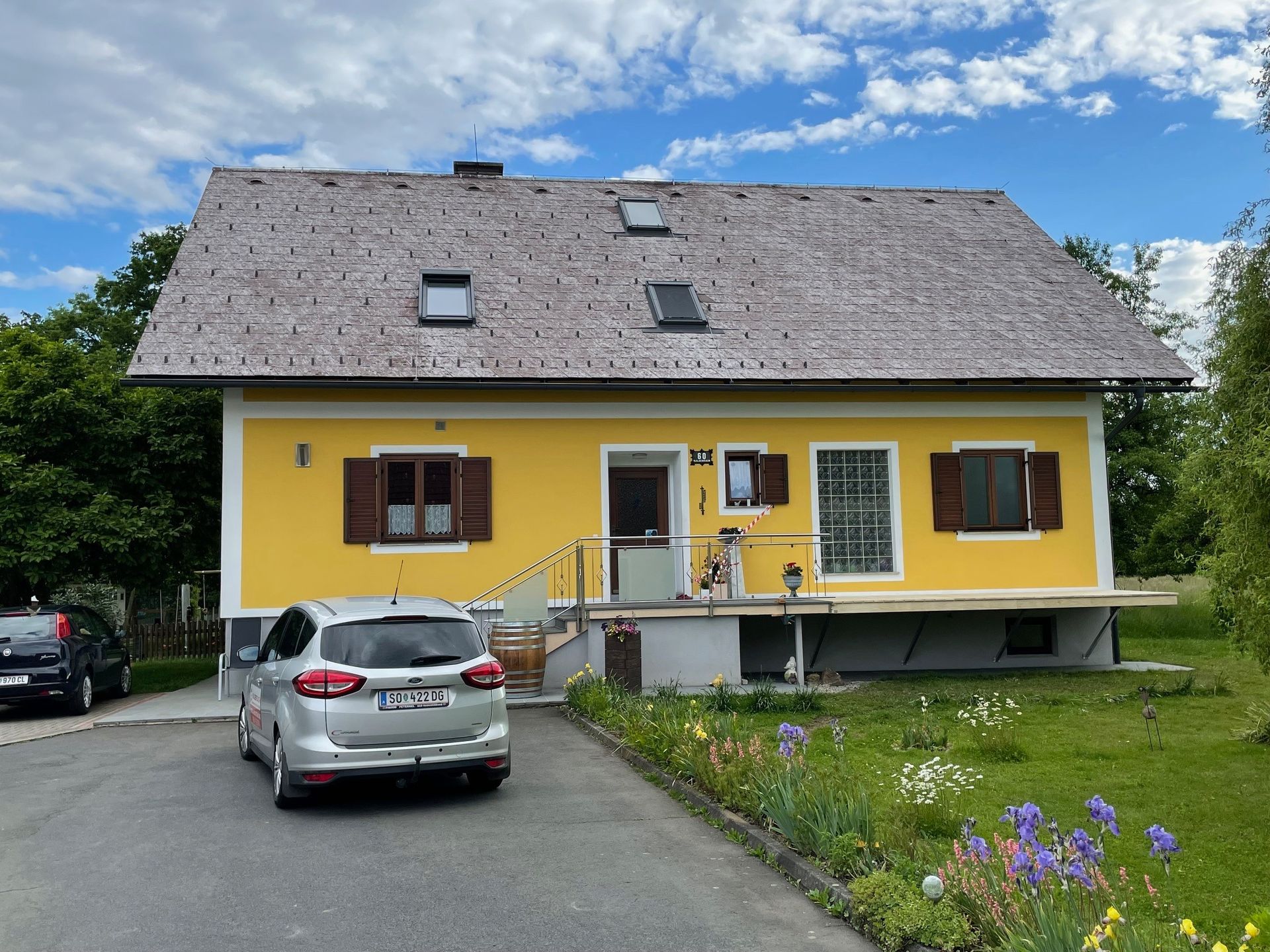 Ein gelbes Haus mit einem davor geparkten Auto