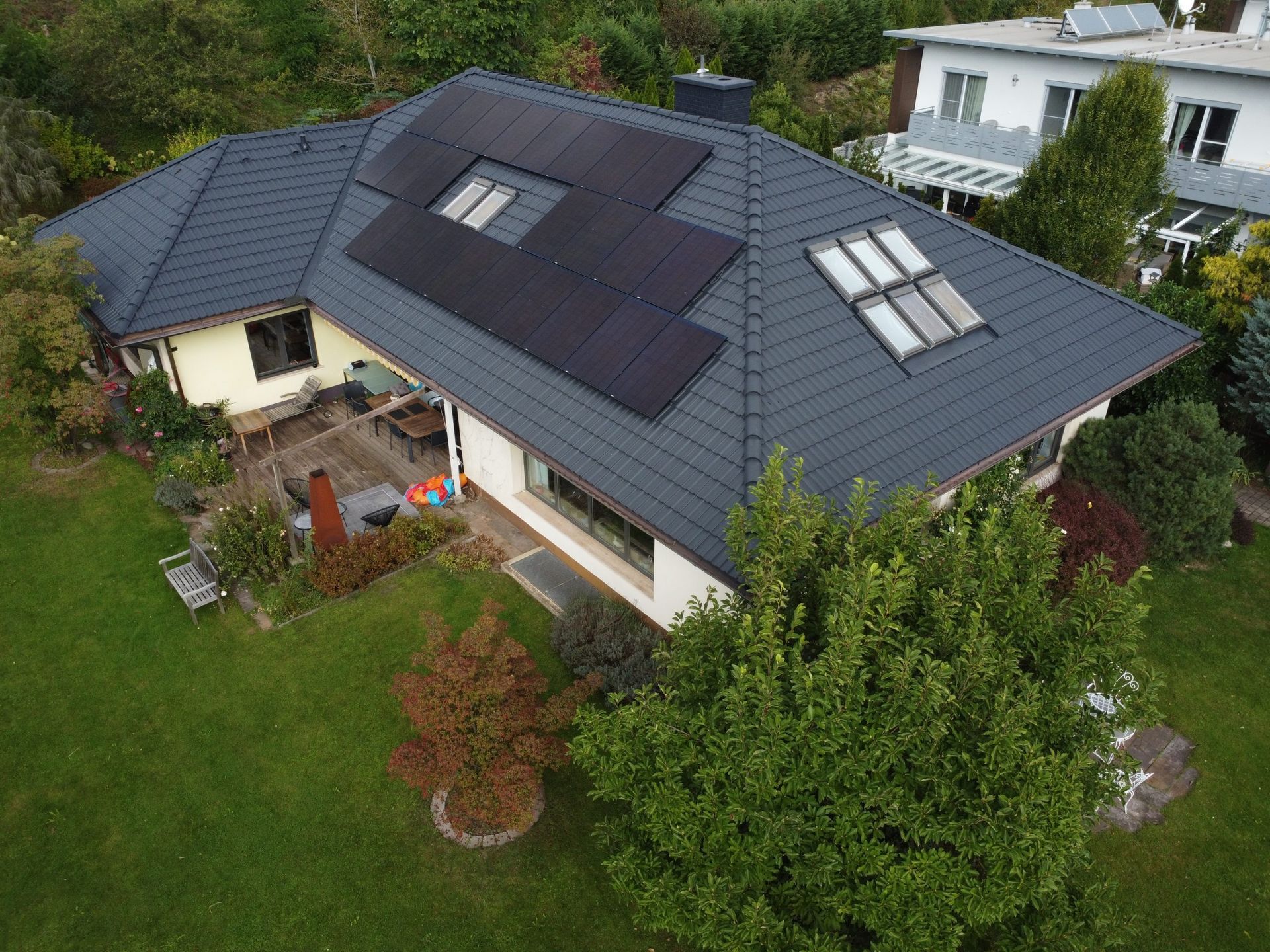 Eine Luftaufnahme eines Hauses mit Solarmodulen auf dem Dach.