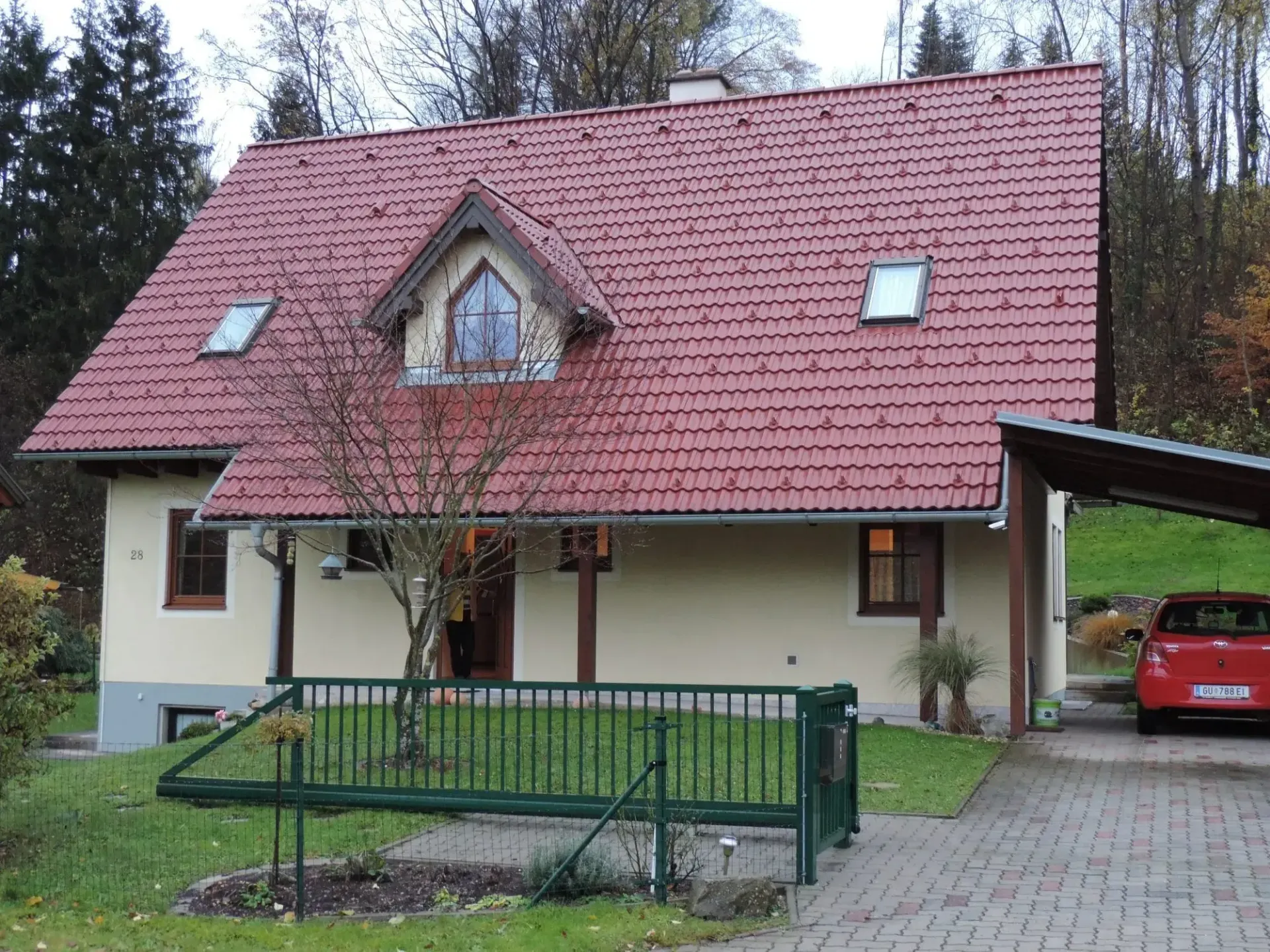 Ein rotes Auto steht vor einem Haus