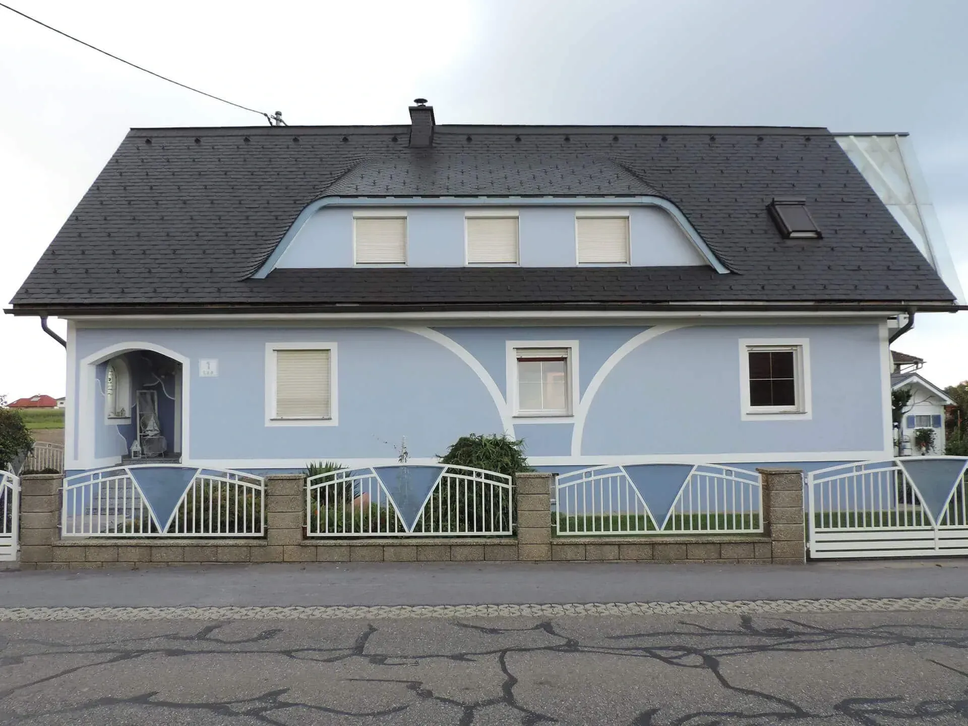 Ein blau-weißes Haus mit einem schwarzen Dach