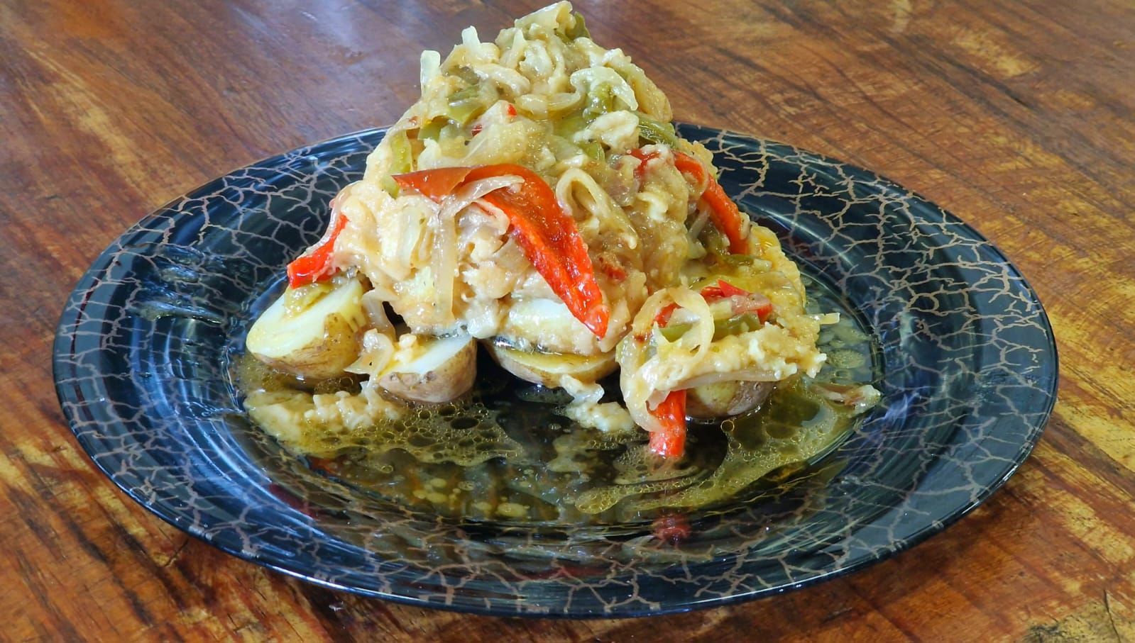 Un plato de comida con verduras en una mesa de madera.