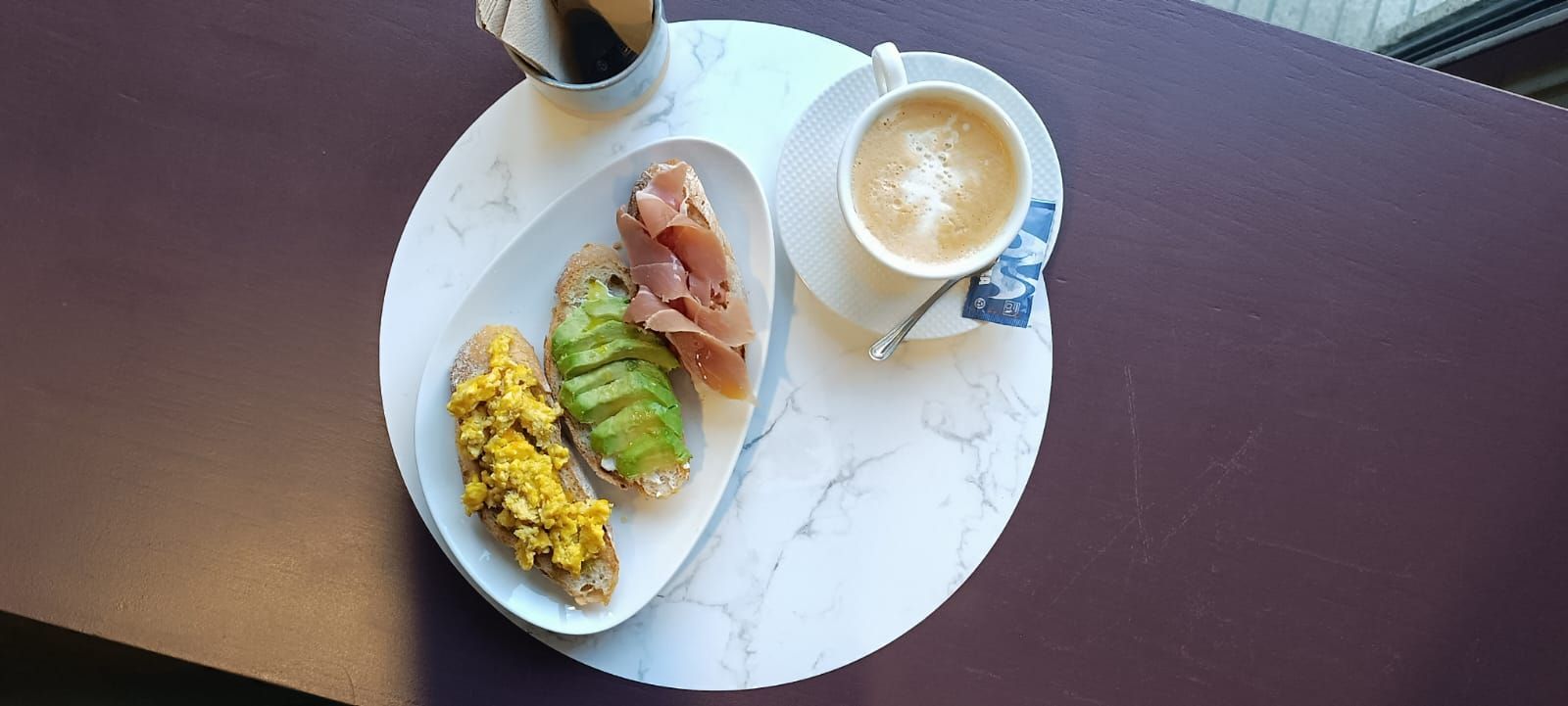 Un plato de comida y una taza de café sobre una mesa.