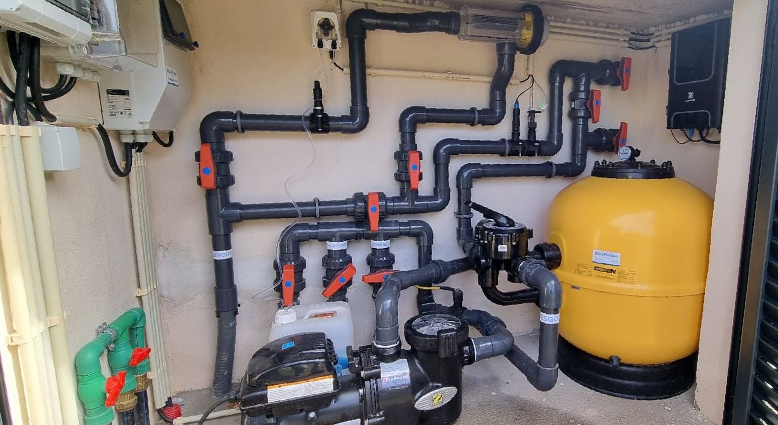 Uma sala cheia de canos e um tanque amarelo.