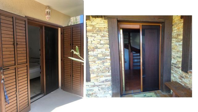 Dos puertas correderas de madera, una entre columnas de piedra, que dan a una zona de patio.