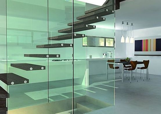 Escalera moderna de cristal en un luminoso interior de vivienda minimalista con zona de comedor.
