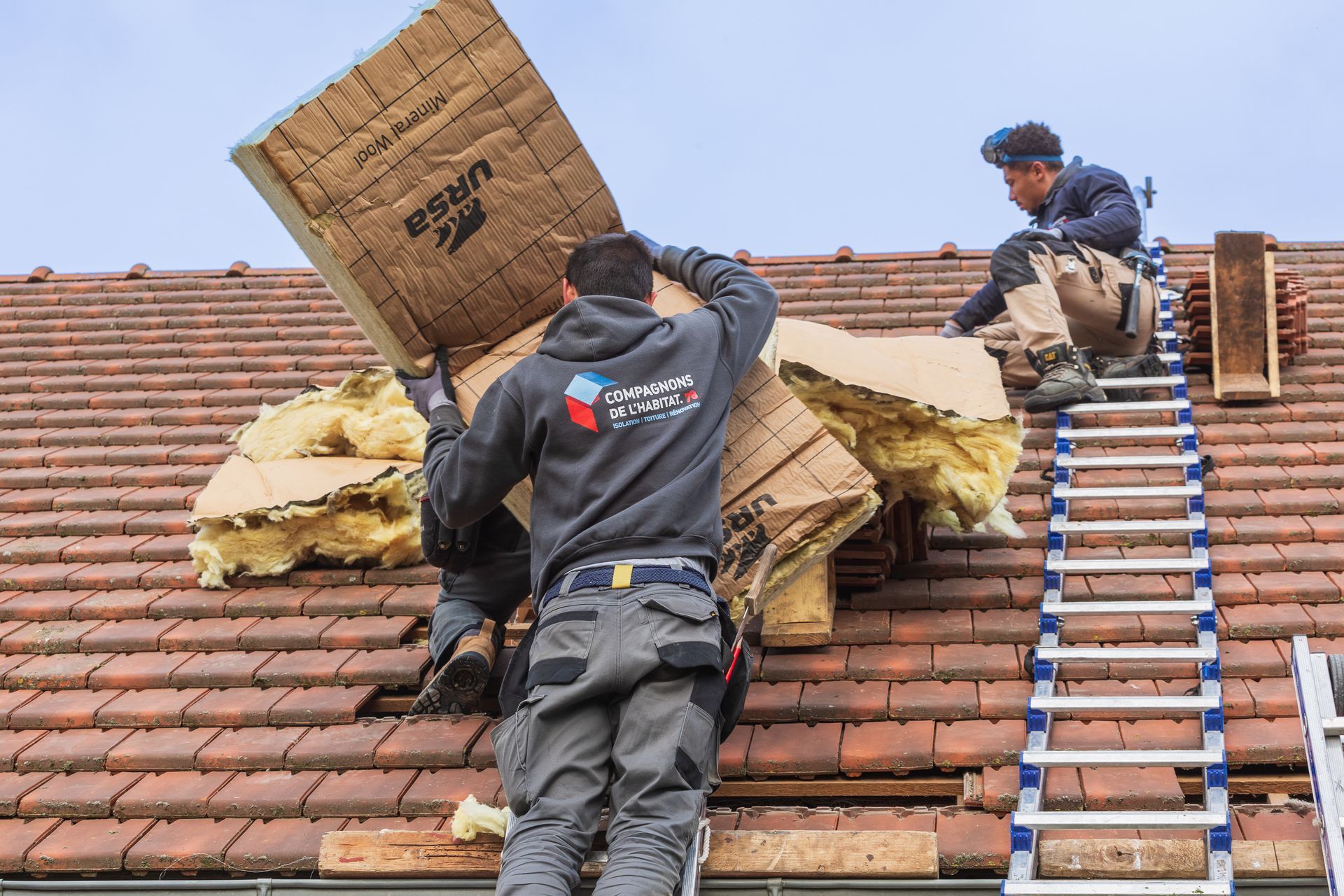 2 employés de l'entreprise les Compagnons de l'Habitat 78 posant de l'isolant