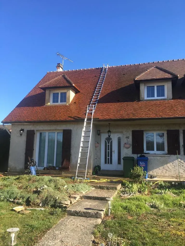 une échelle posée sur la toiture d'une maison