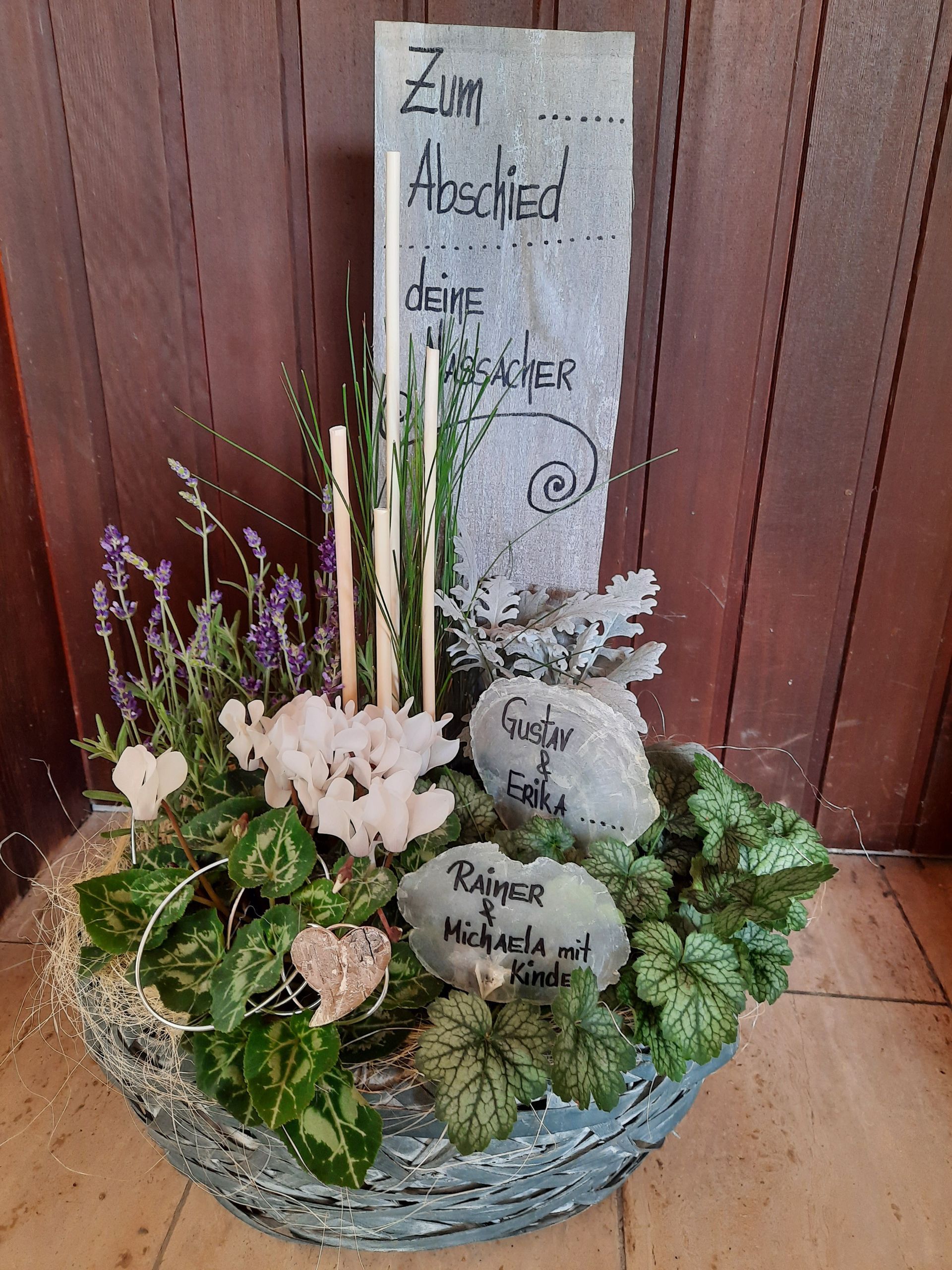 Memorial arrangement with stone and flowers; includes text: 