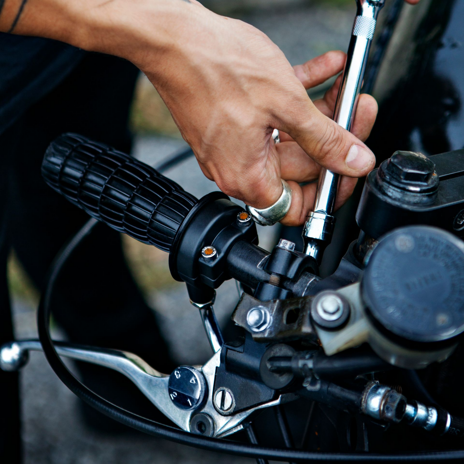 Main d'un homme réparant une moto