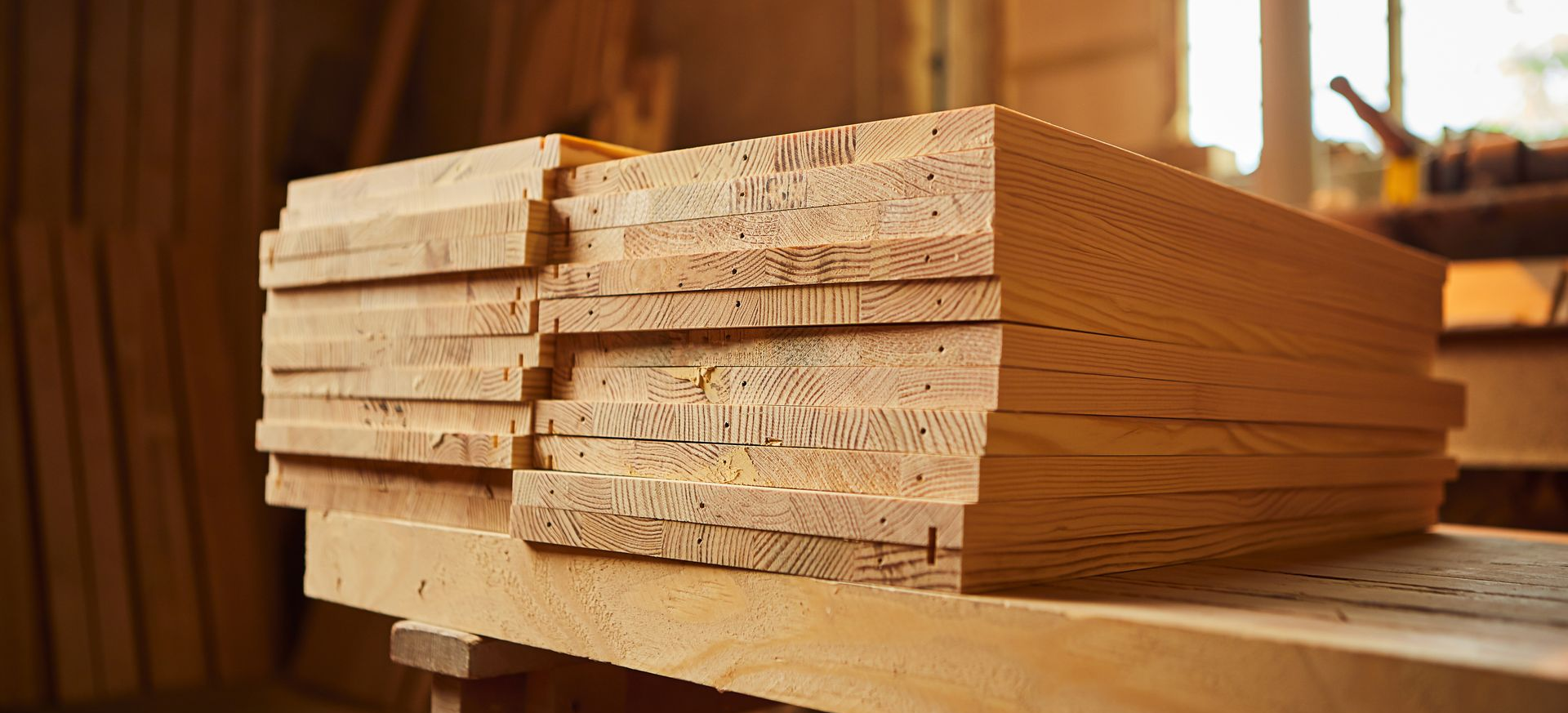 Pile de planches de bois sur un établi dans un atelier.
