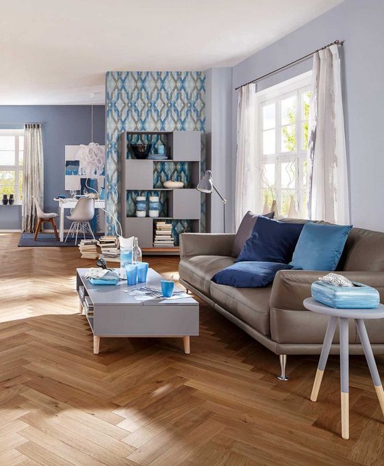 Wohnzimmer in Blau- und Grautönen mit Couch, Zierkissen und Couchtisch