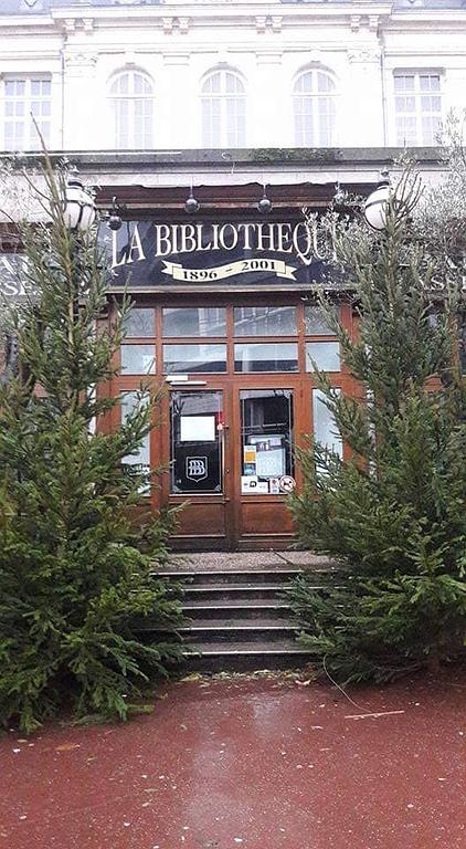 Entrée d'une bibliothèque entourée de sapins
