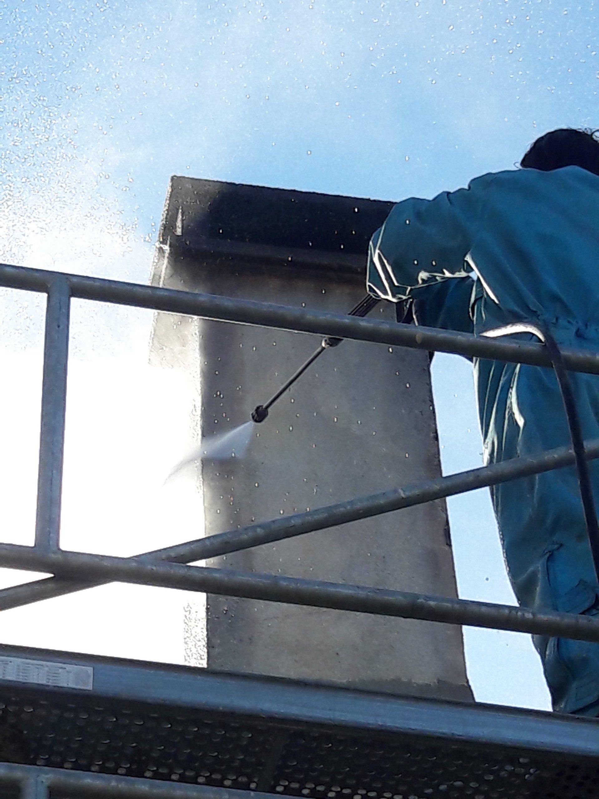 Ouvrier nettoyant une cheminée avec un jet d'eau