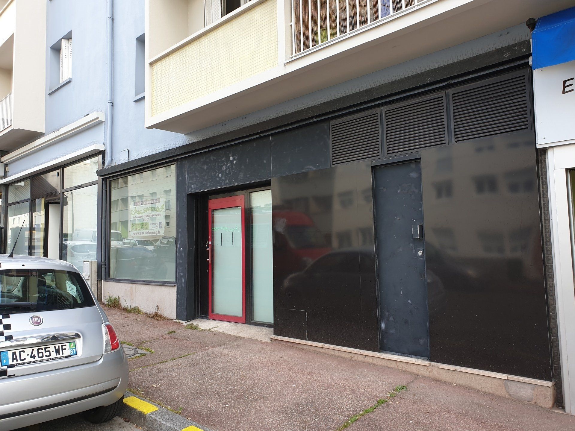 Mur noir avec une porte rouge