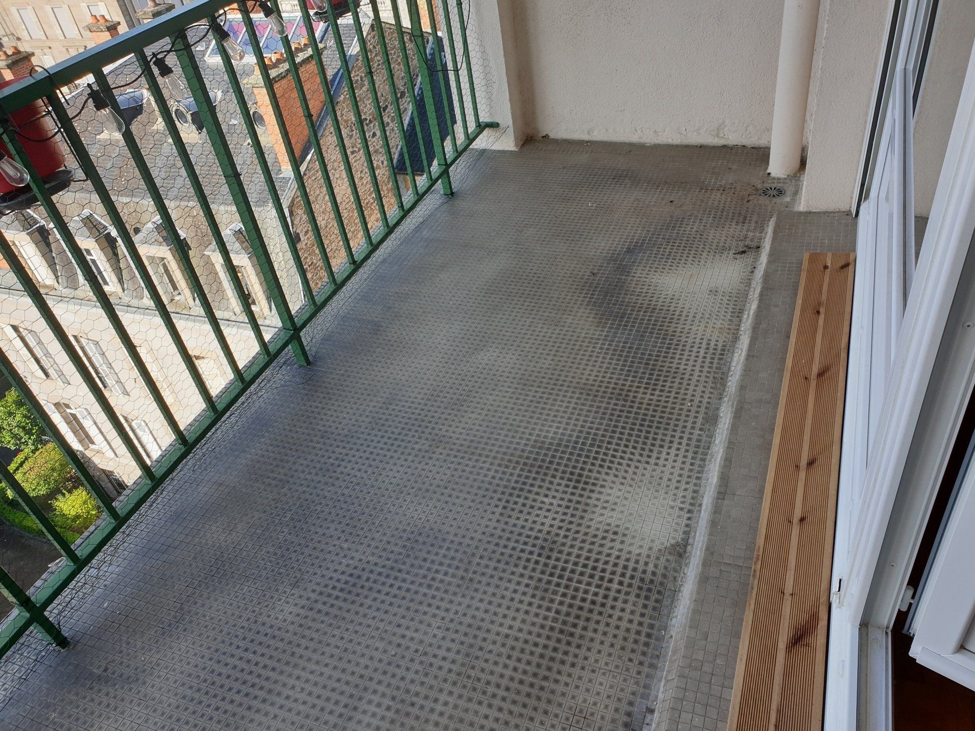 Balcon avec un sol en béton en clôture verte