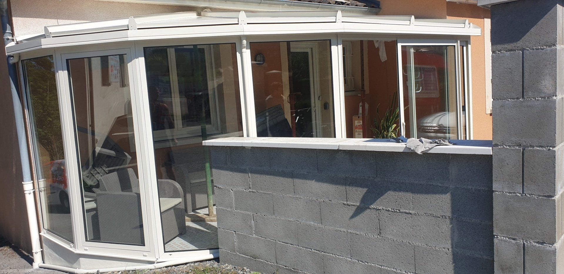 Véranda aluminium derrière un muret