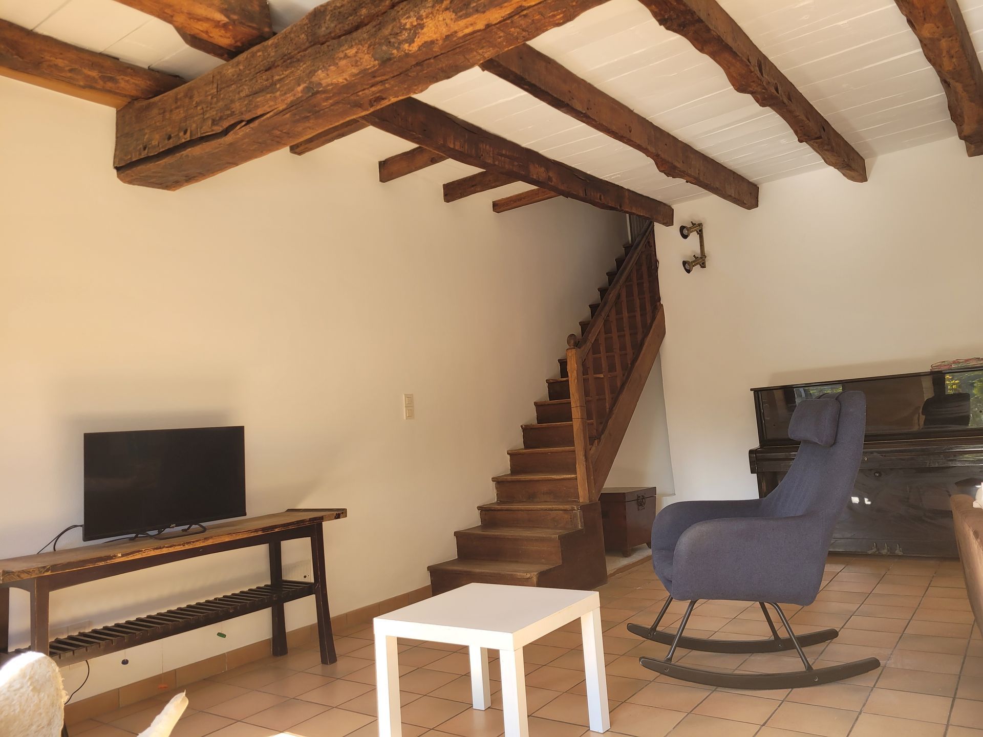 Salon modernisé avec plafond rénové et poutres en bois apparentes