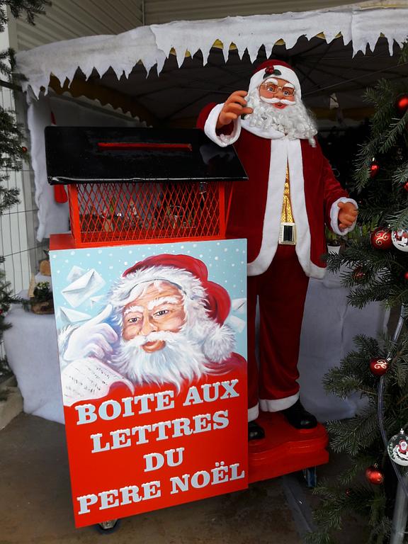 Stand avec un statue de père Noël à côté de sa boîte aux lettres