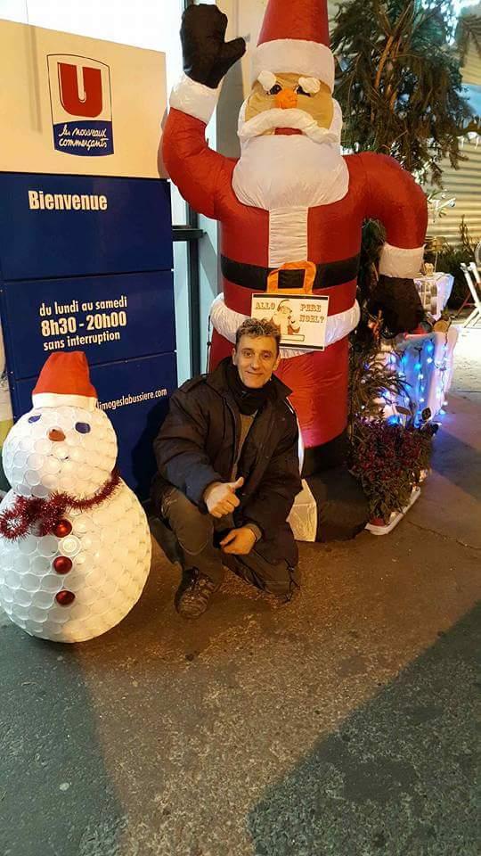 Homme posant devant un père Noël
