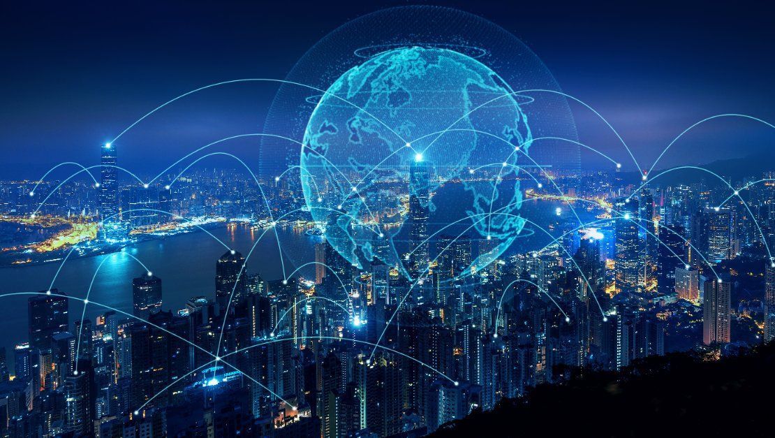 Paisaje urbano nocturno con un globo digital brillante superpuesto, conectado por líneas luminosas, que simbolizan redes de datos globales.