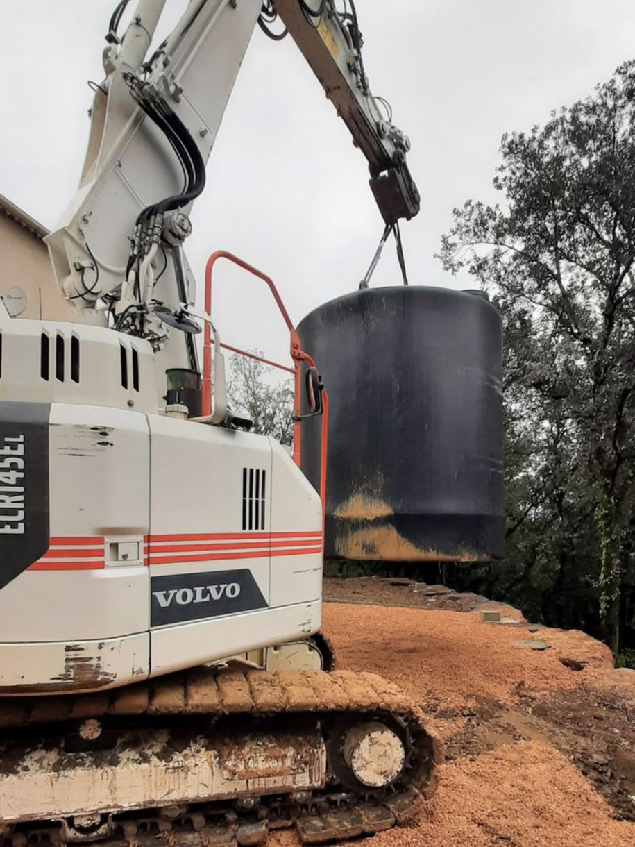 Un excavateur qui porte une cuve d'eau
