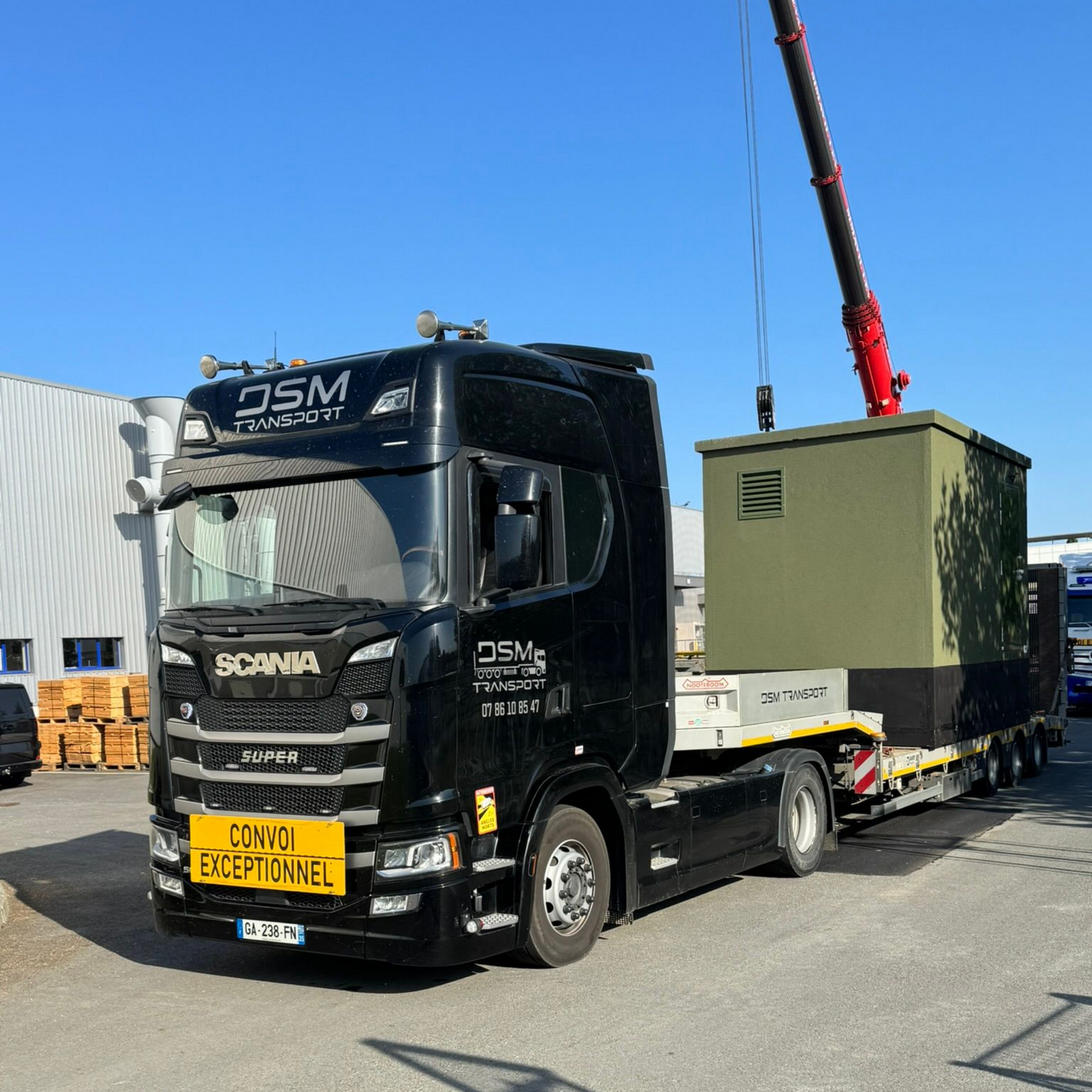 Transport en convoi exceptionnel avec camion plateau et levage de module industriel par grue.