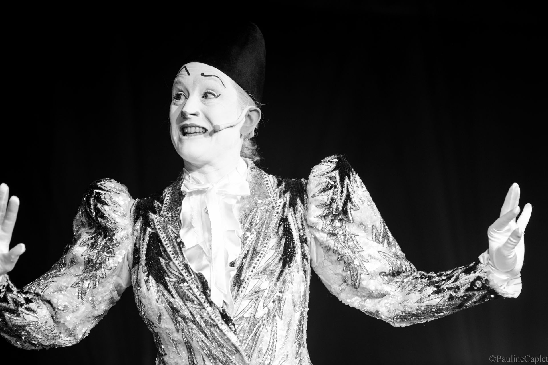 Une femme en costume de clown joue du violon