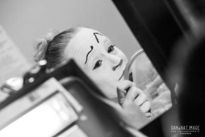 Une femme regarde son visage dans un miroir.