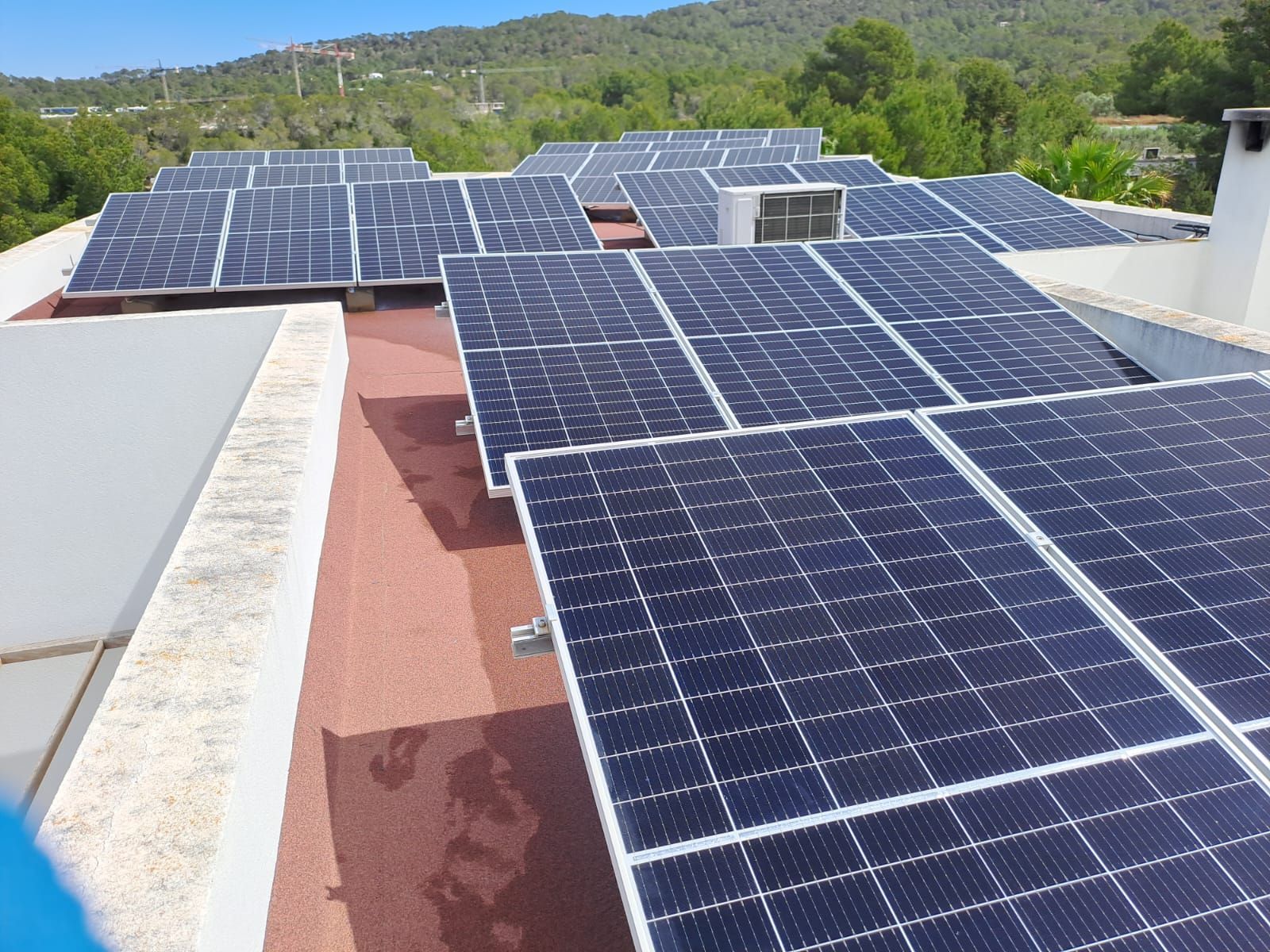 Paneles solares en un tejado plano en un entorno soleado, generando energía limpia.