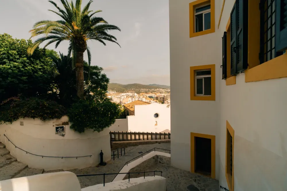 Cañón en un muro de piedra con vistas a una ciudad al atardecer.