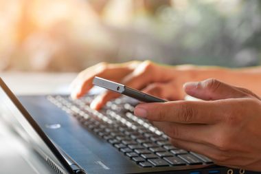 Une personne avec un ordinateur et un téléphone