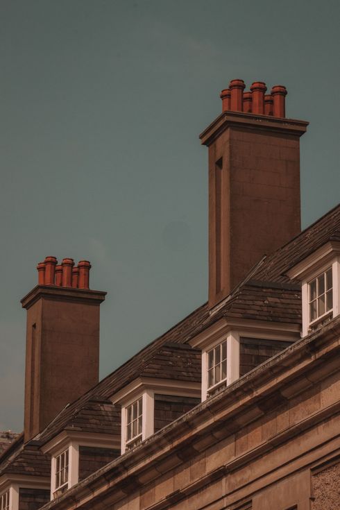 Chimeneas de ladrillo en una azotea contra el cielo crepuscular