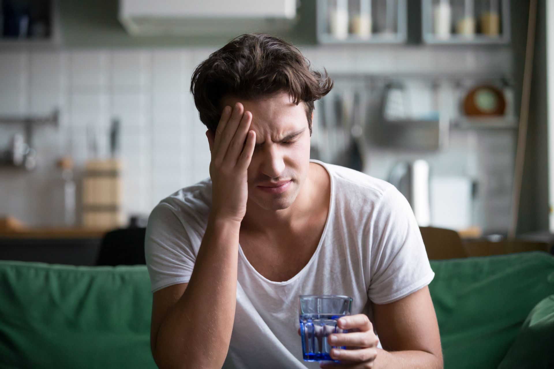 Un homme touche sa tête douloureuse