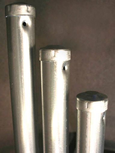 Tres tubos de metal están colocados uno al lado del otro sobre una mesa.