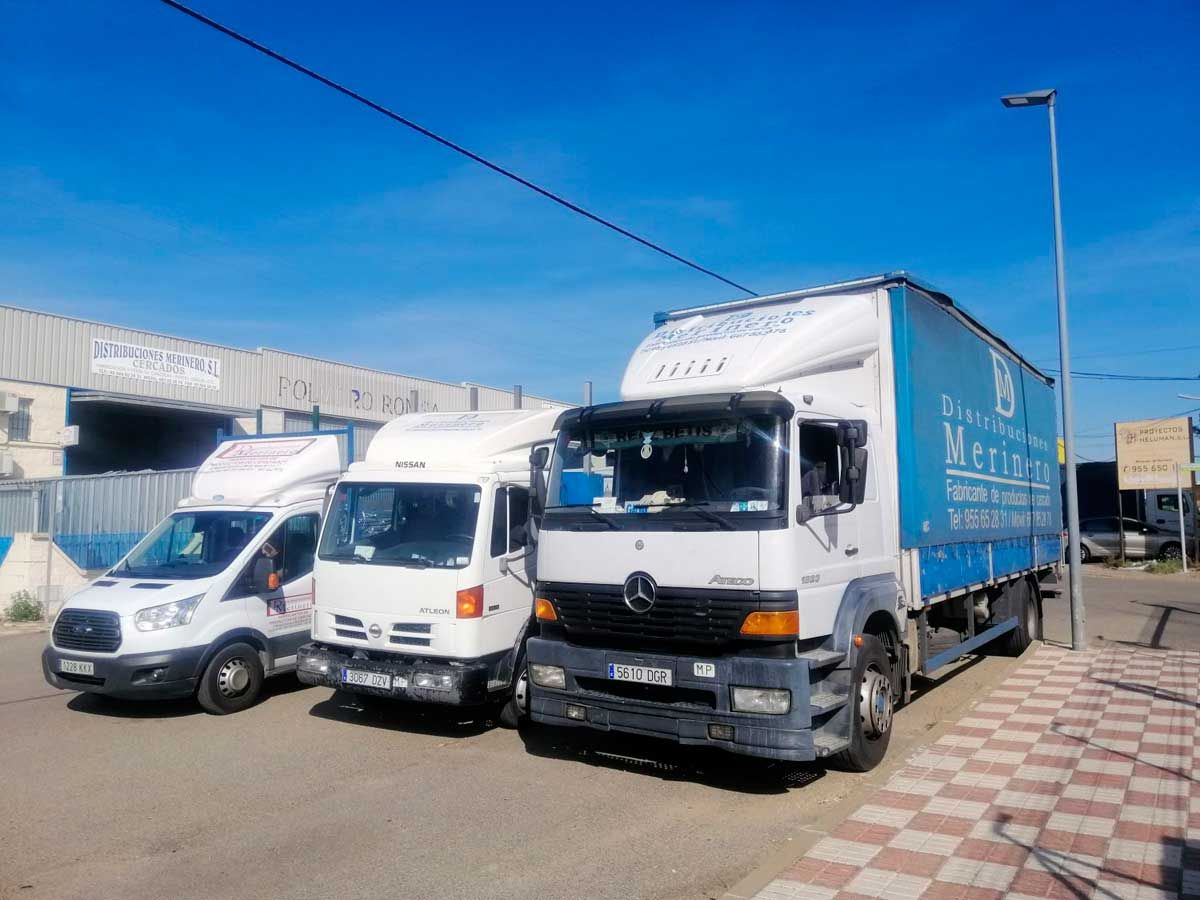 Tres camiones están estacionados uno al lado del otro al costado de la carretera.