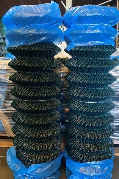 Dos bolsas de alambre de eslabones de cadena están apiladas una encima de otra sobre una mesa.