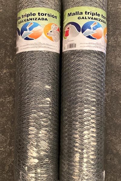 Dos rollos de malla triple torsión galvanizada están sobre una mesa.